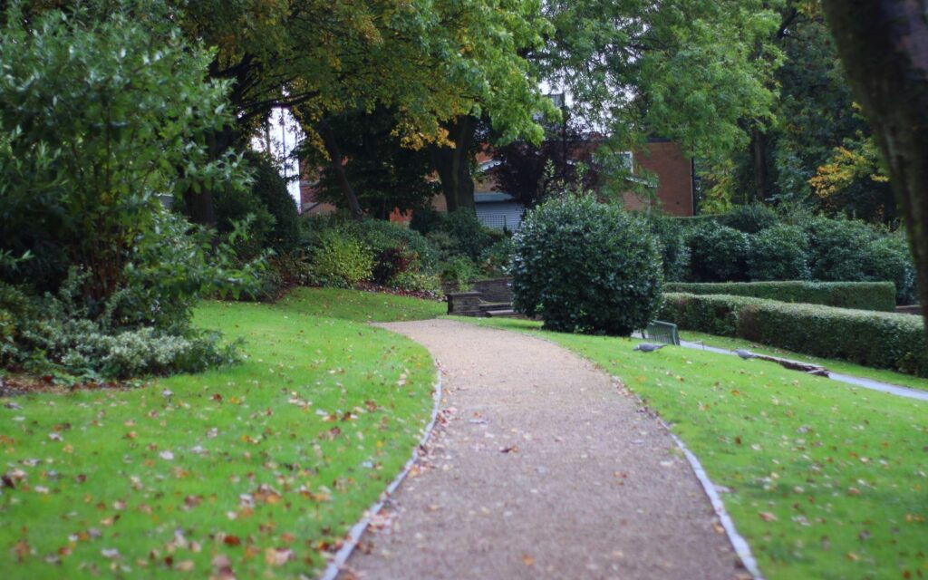 Firm garden path through a green park