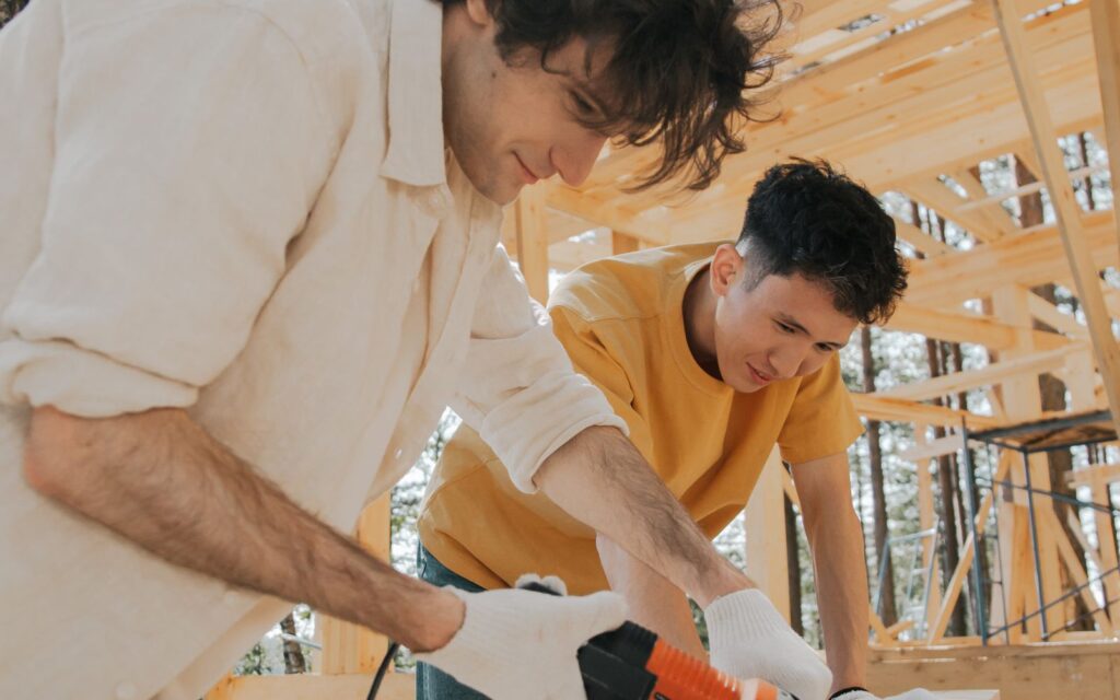 Two people working on a timber build outdoors