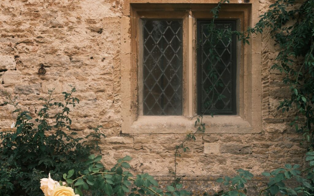 Old stone wall with a yellow rose bush