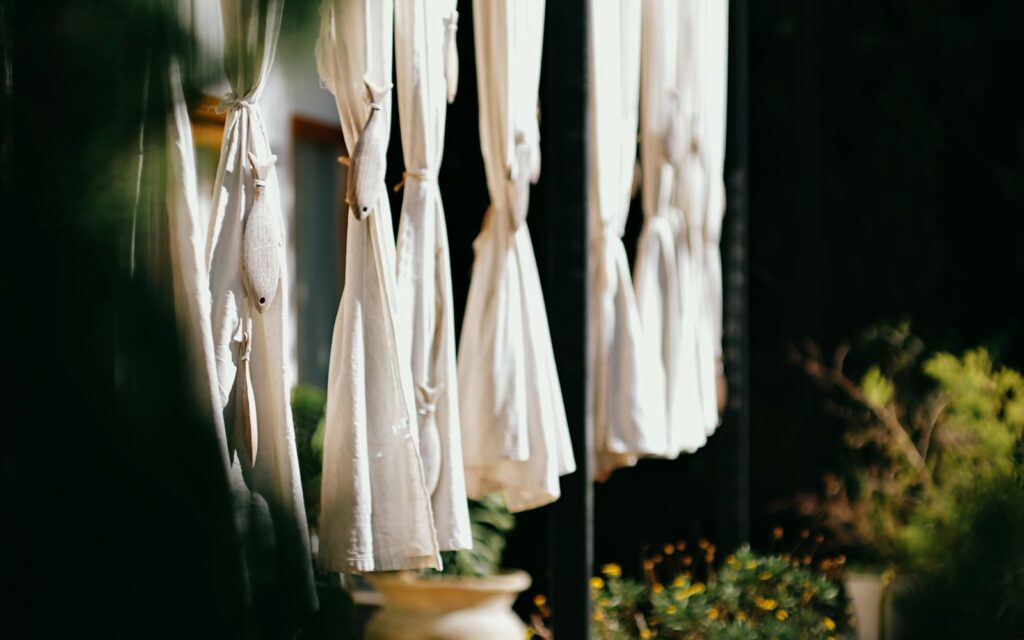 Outdoor curtains draped around a garden seating area