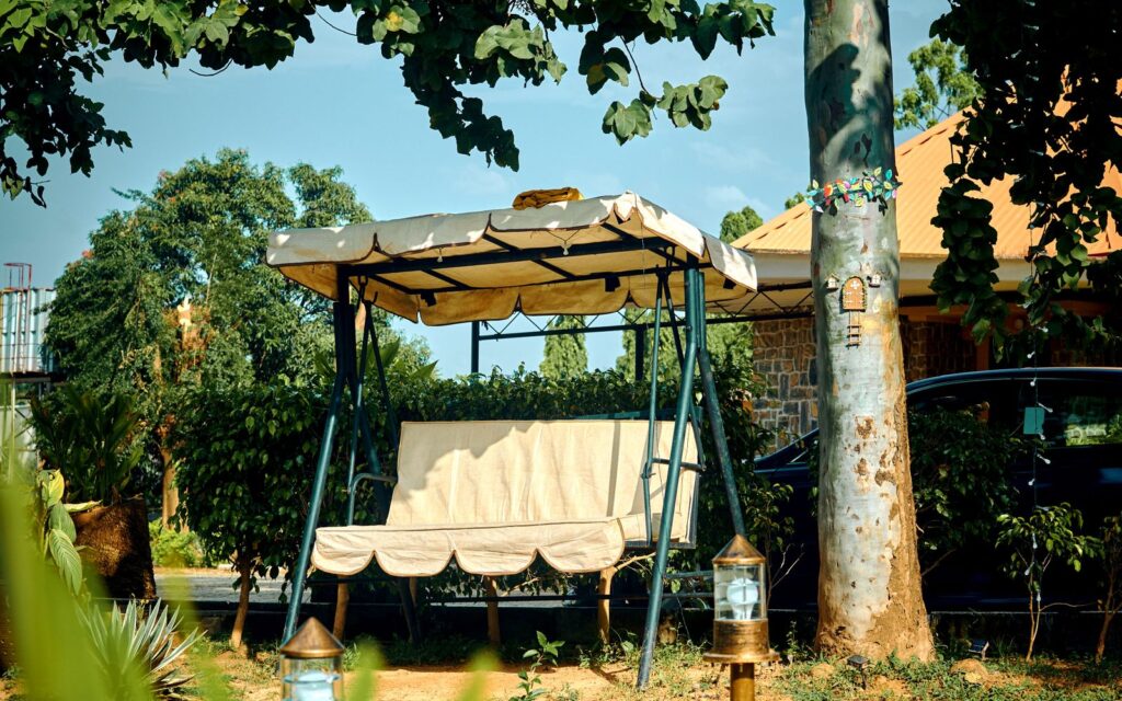 Swing bench under a large tree in a garden