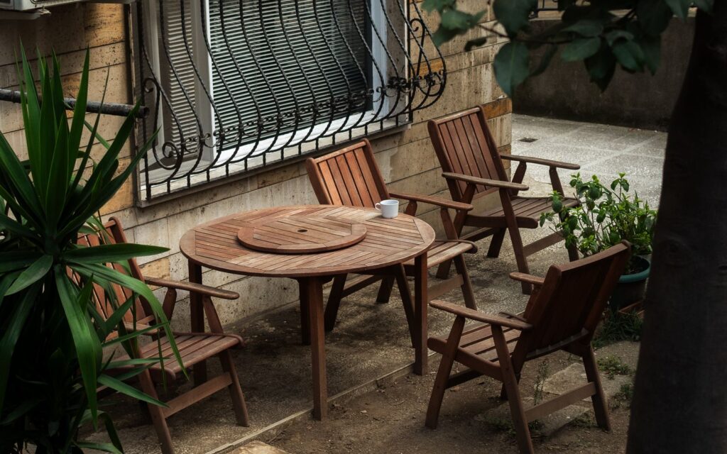 Relaxing backyard patio with wooden chairs and a round table