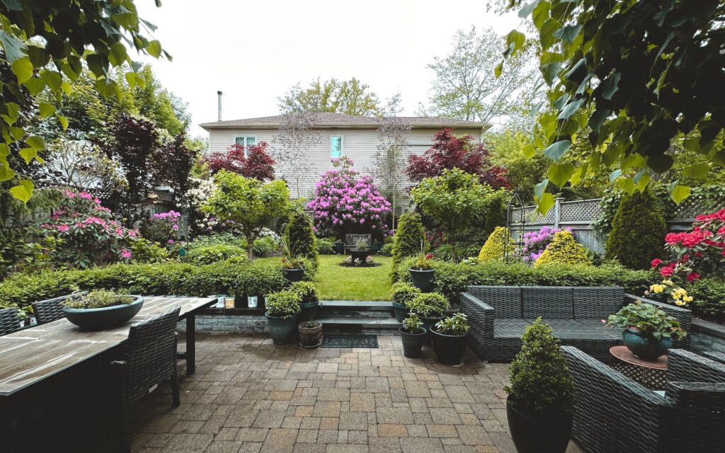 Small backyard garden with flowers and patio furniture