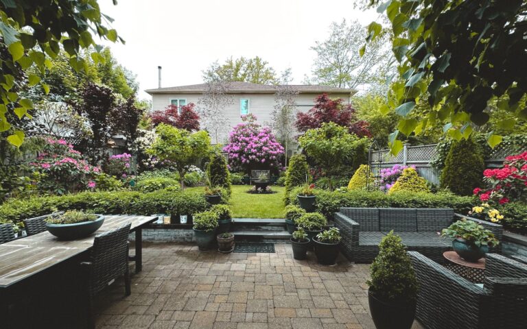 Small backyard garden with flowers and patio furniture