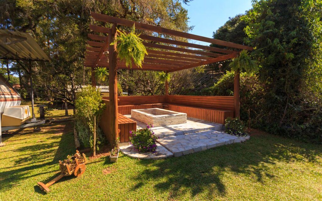 Timber gazebo with a solid roof over a stone patio