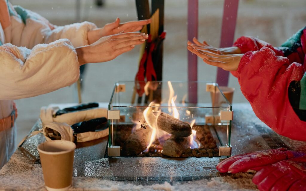 Warming hands by an outdoor fire on a snowy day