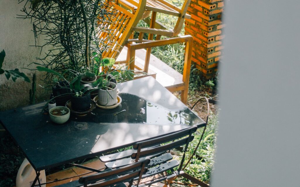 Small garden patio with potted plants and vintage furniture