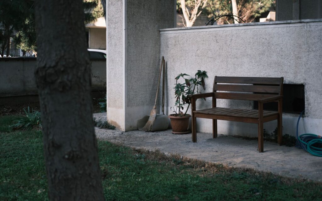 Wooden bench against a wall in a small garden