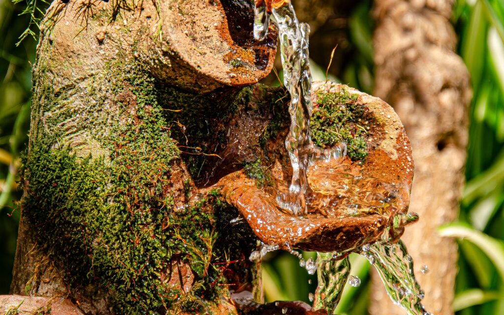 Small terracotta water fountain in a garden