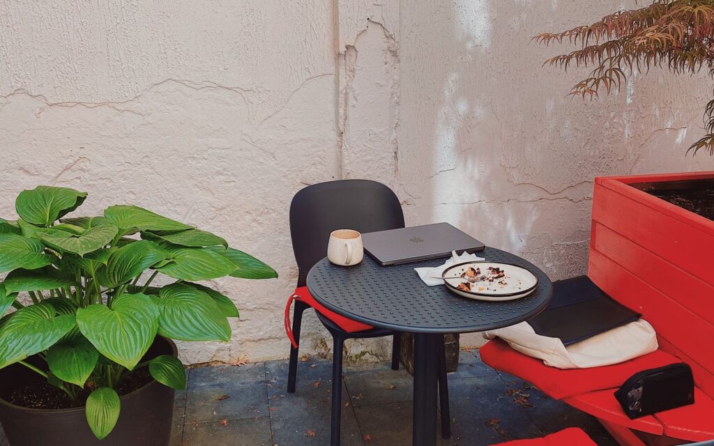 Stylish patio with modern chairs, table and potted plants