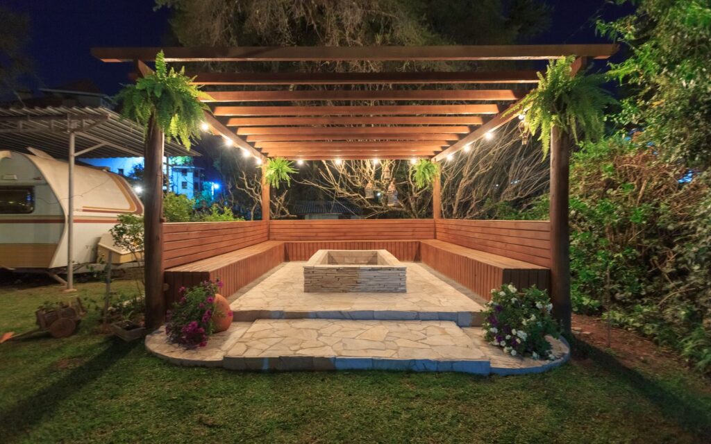 Outdoor fireplace with wooden benches at night